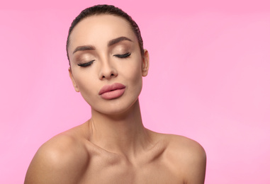 Beautiful woman with matte lipstick on pink background
