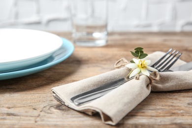 Cutlery set and dishware on wooden table, closeup