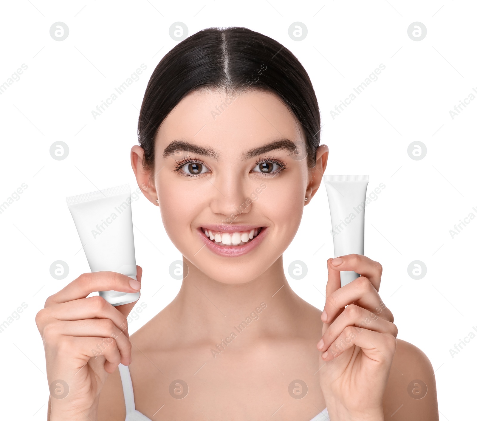 Photo of Teenage girl holding tubes of foundation on white background