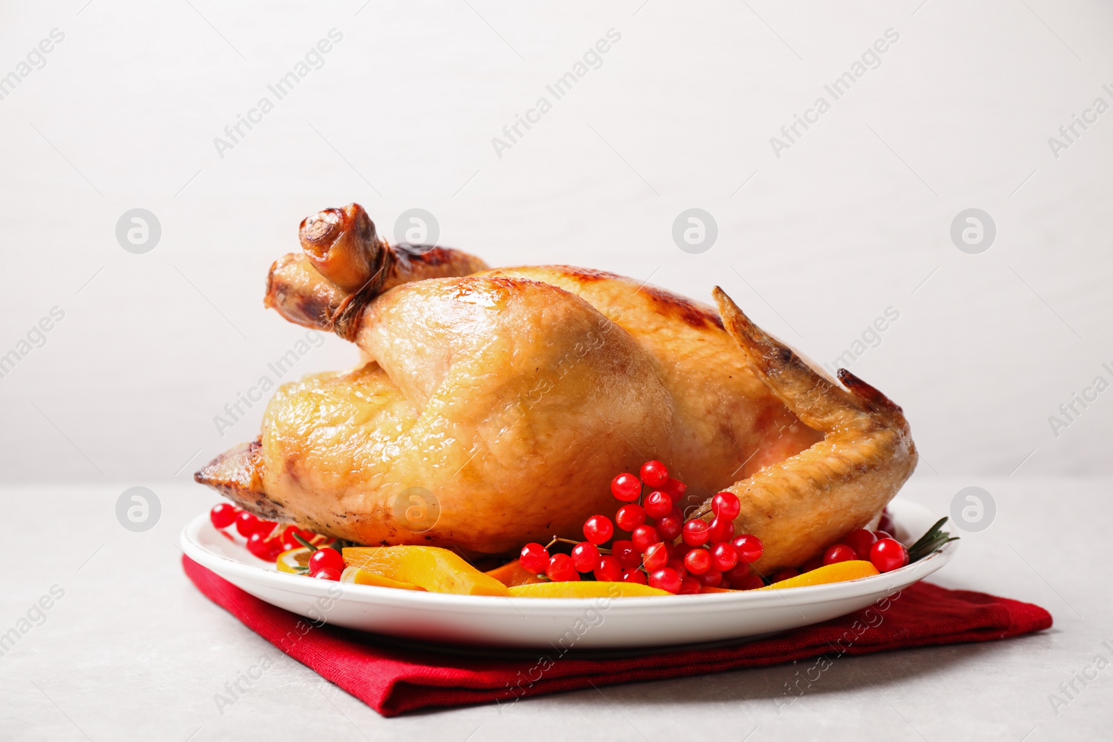 Photo of Delicious cooked turkey served on light table. Thanksgiving Day celebration