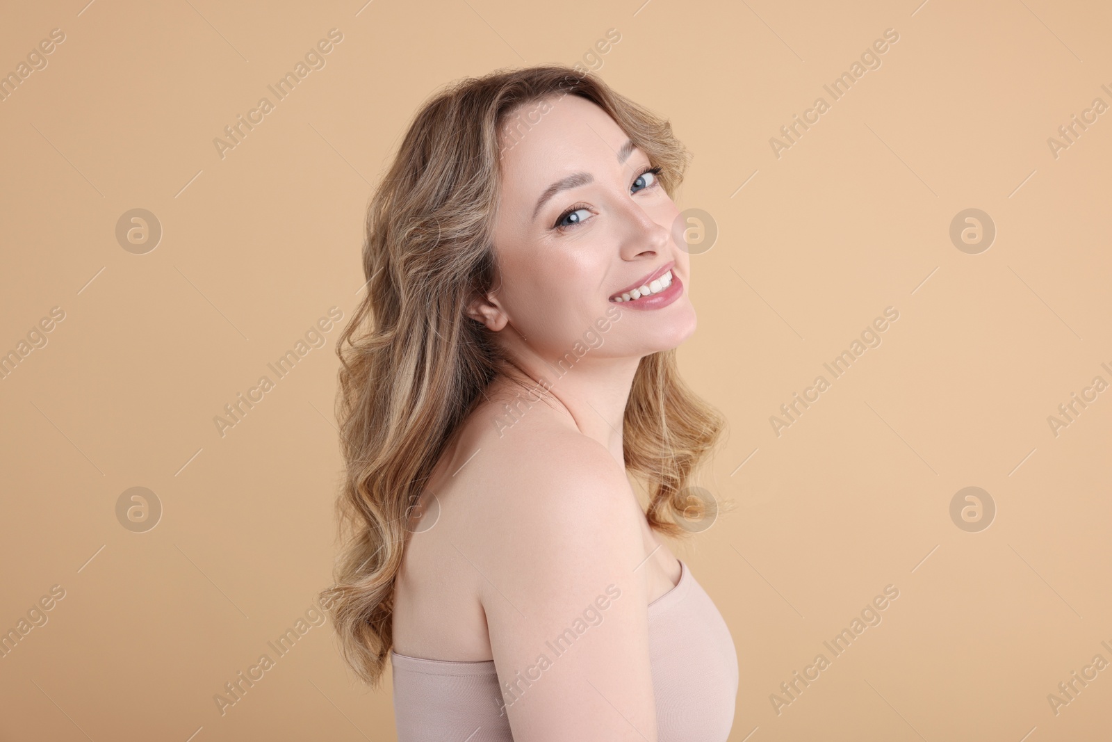 Photo of Portrait of smiling woman on beige background