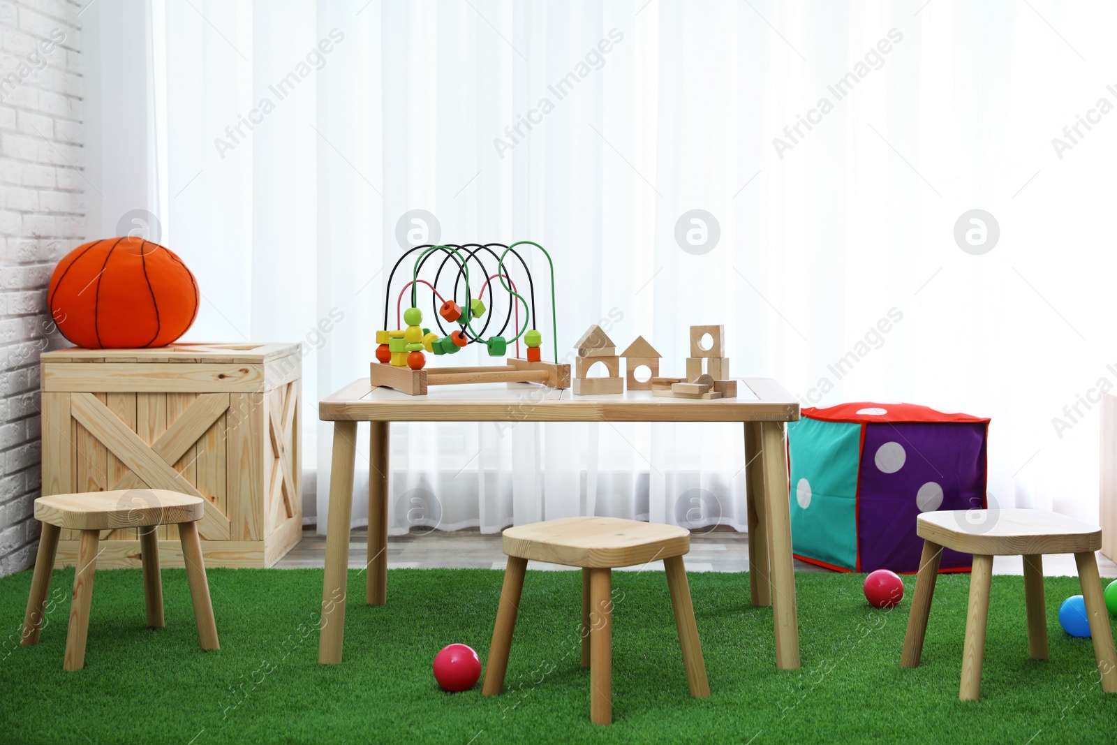 Photo of Stylish playroom interior with toys and modern wooden furniture