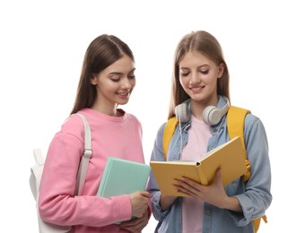 Teenage students with books and backpacks on white background