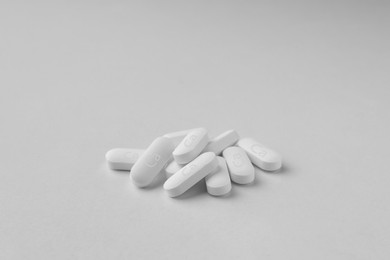 Photo of Pile of calcium supplement pills on light grey background