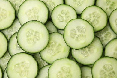 Photo of Fresh slices of cucumbers as background, top view