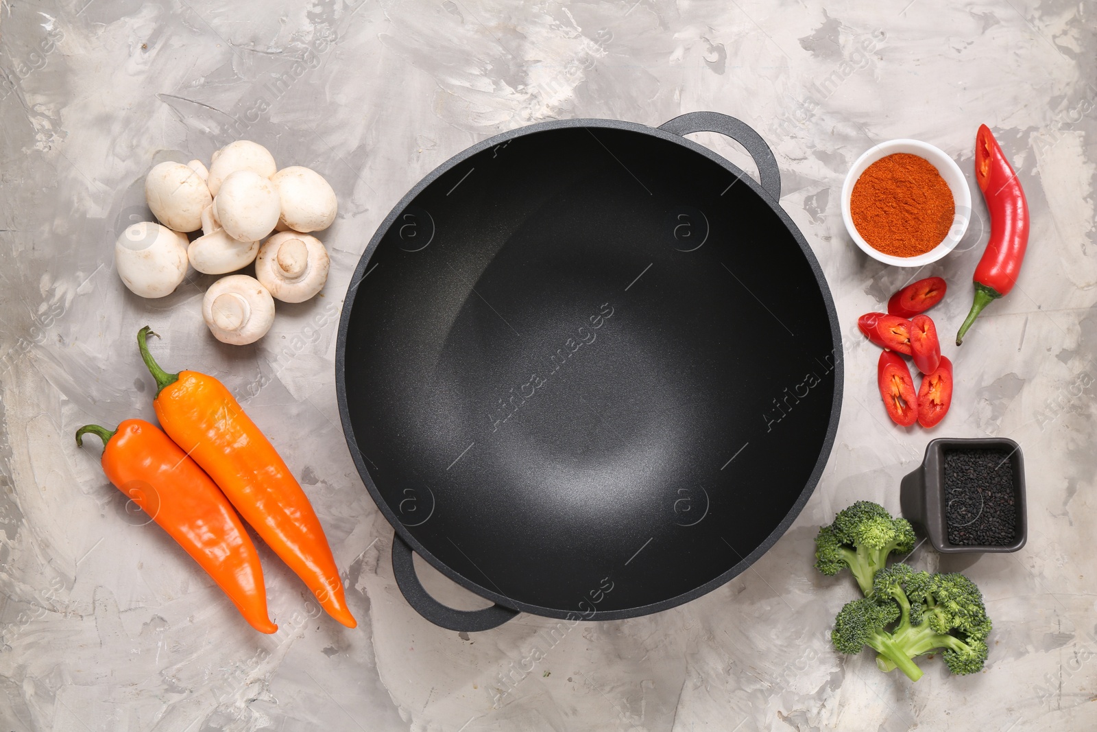 Photo of Wok and different products on grey textured table, flat lay