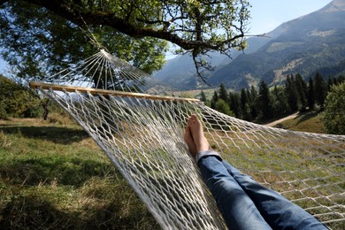 Photo of Man resting in hammock outdoors on sunny day, closeup