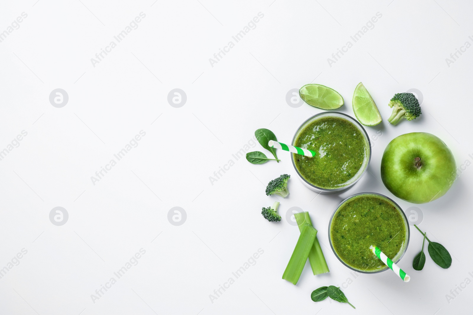 Photo of Delicious green juice and fresh ingredients on white background, flat lay. Space for text