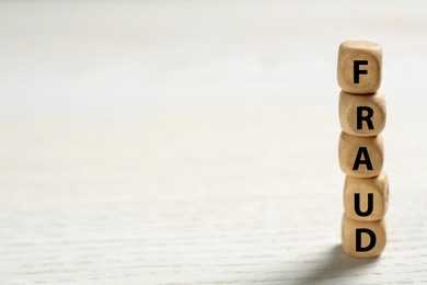 Word Fraud of cubes with letters on white wooden background. Space for text