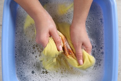 Woman washing garment with stain, top view