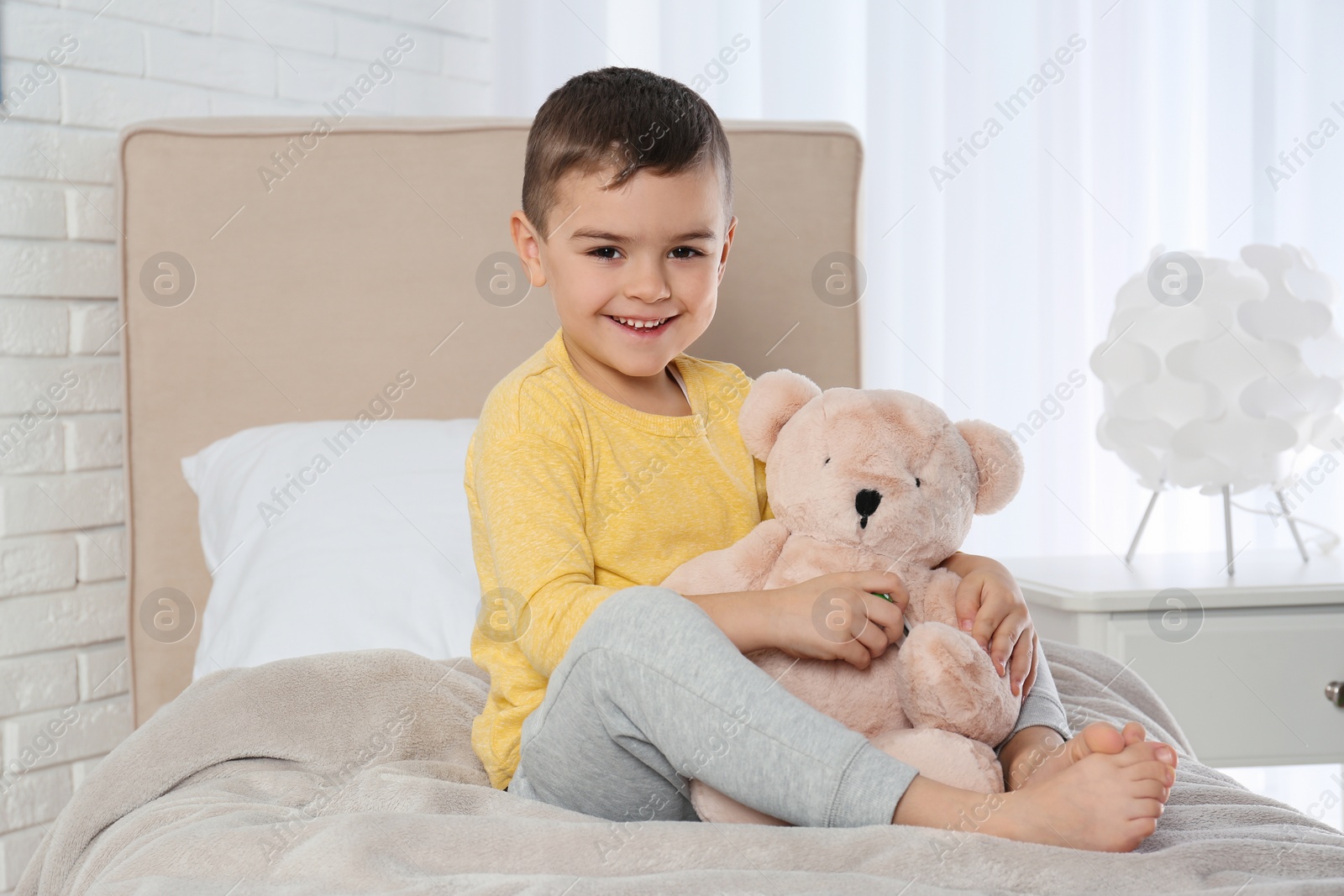 Photo of Cute child playing doctor with stuffed toy at hospital