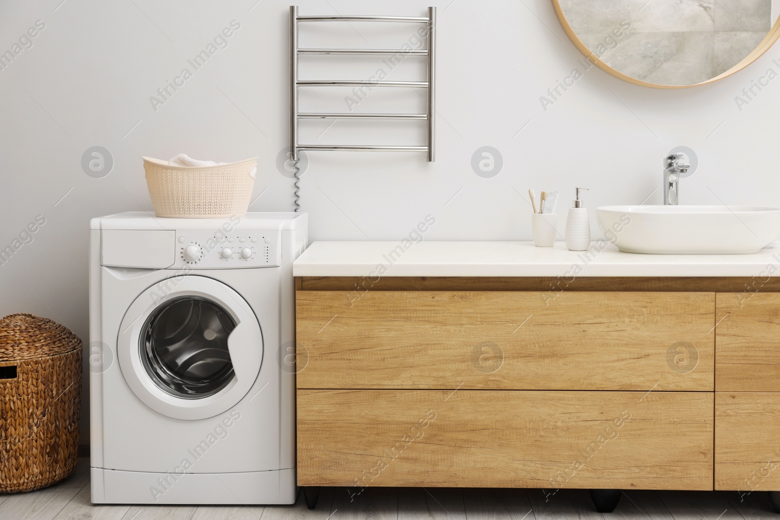 Photo of Stylish bathroom interior with heated towel rail and washing machine