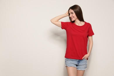 Young woman in t-shirt on light background. Mock up for design