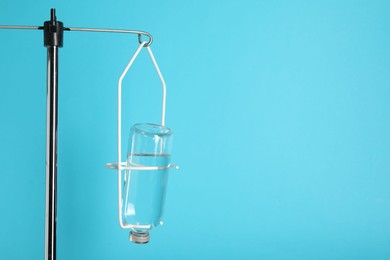 IV infusion set on pole against light blue background. Space for text