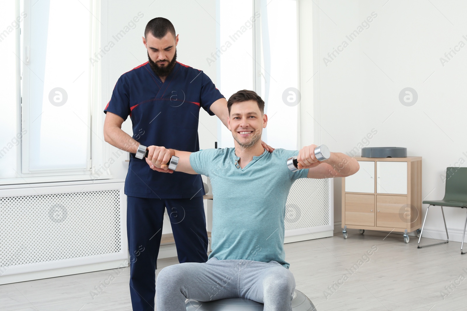 Photo of Physiotherapist working with patient in clinic. Rehabilitation therapy