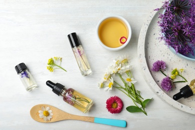 Photo of Flat lay composition with bottles of essential oils on light background