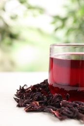 Photo of Fresh Hibiscus tea on white table against blurred background, closeup. Space for text