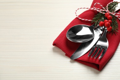 Photo of Cutlery set and festive decor on white wooden table, closeup with space for text. Christmas celebration