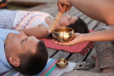 Photo of Couple at healing session with singing bowl outdoors