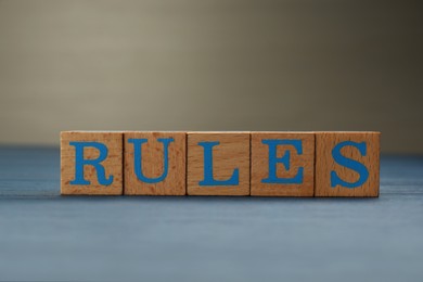 Word Rules made of cubes with letters on light blue wooden table