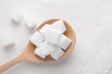 Different types of white sugar and spoon as background, top view. Space for text