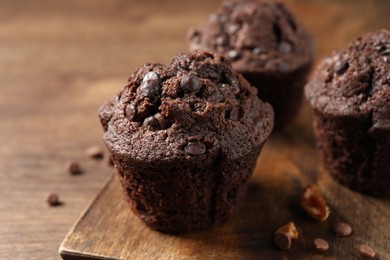 Delicious chocolate muffins on wooden table, closeup