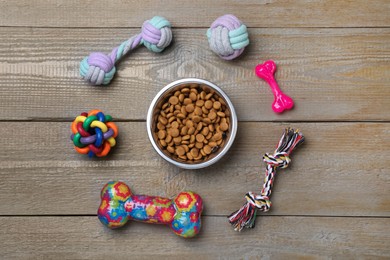 Photo of Flat lay composition with different pet toys and feeding bowl on wooden background