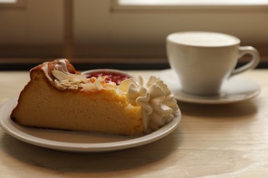 Photo of Cup of aromatic cappuccino and delicious dessert on white wooden table, closeup