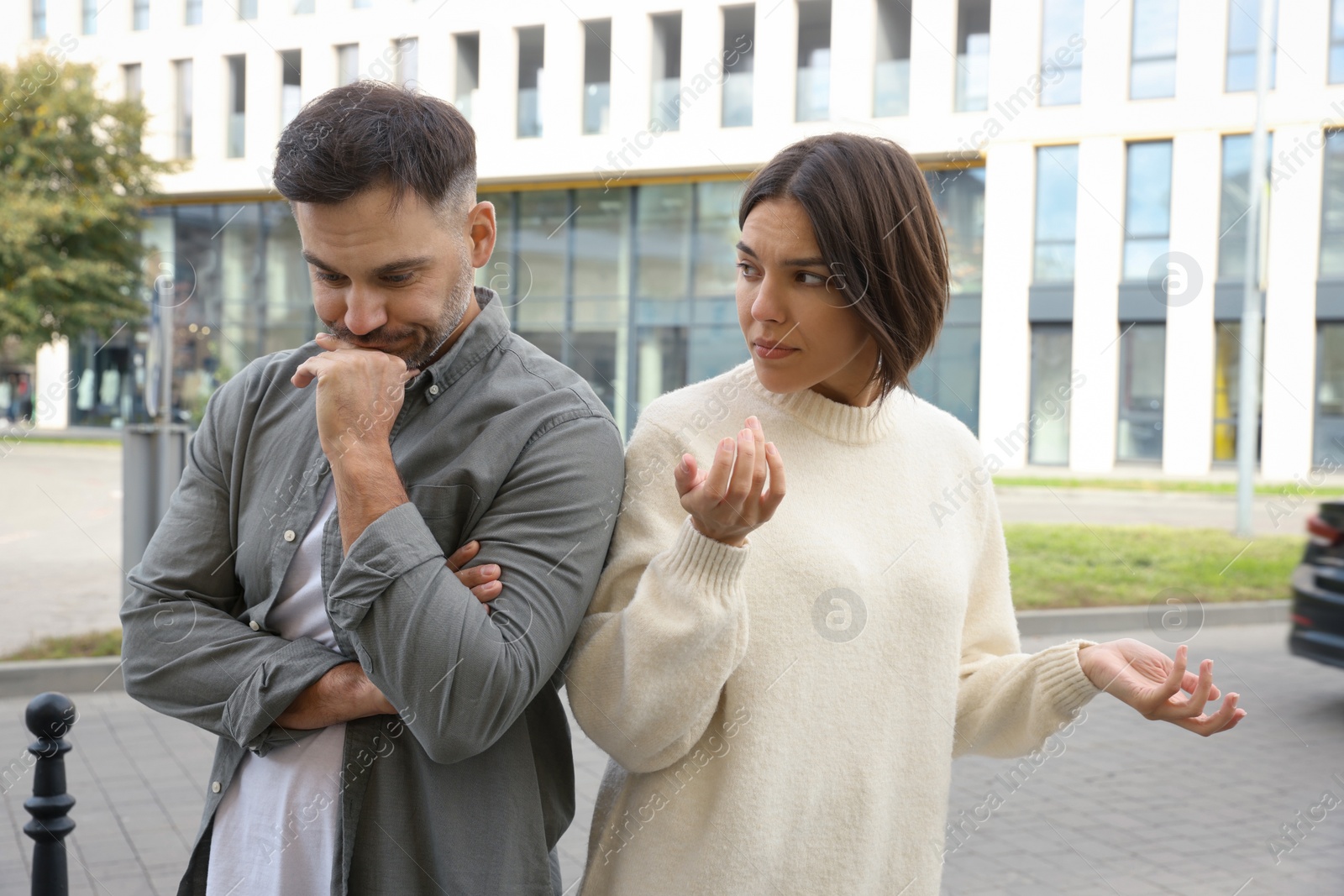 Photo of Couple arguing on city street. Relationship problems