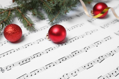 Composition with Christmas balls and fir tree branches on music sheets