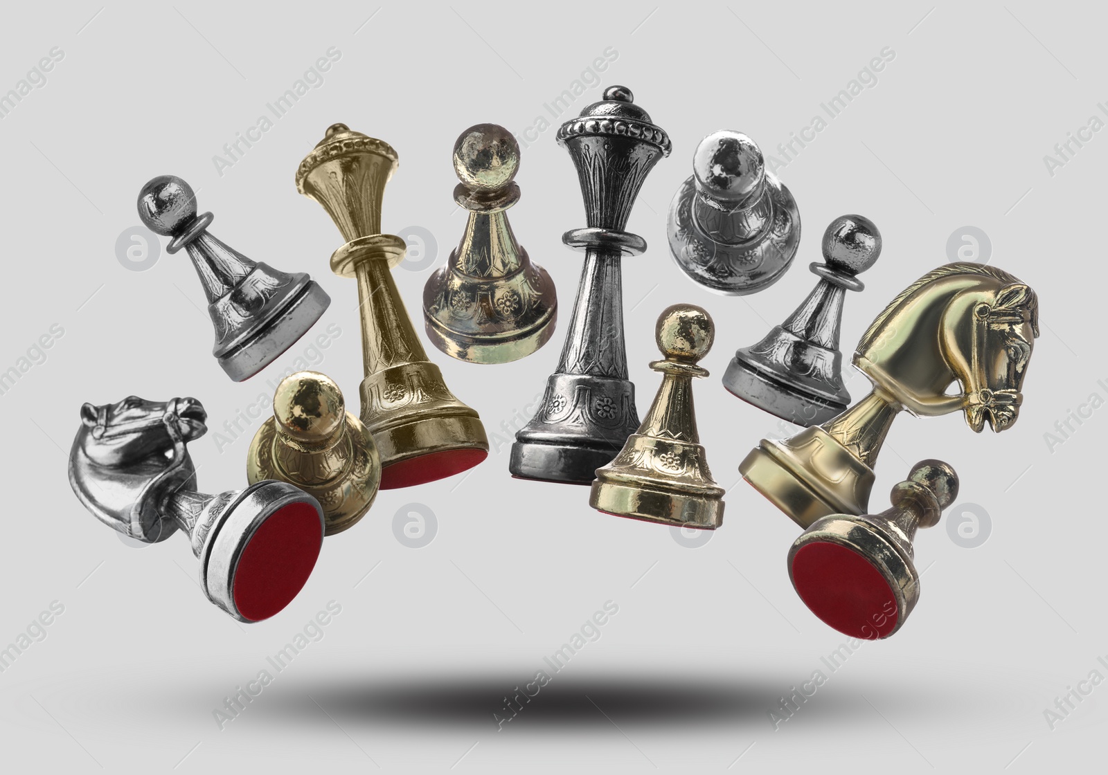 Image of Different chess pieces falling on light grey background