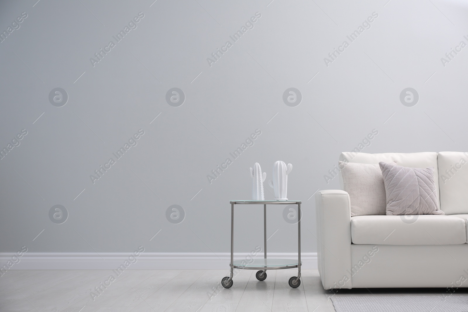 Photo of Simple room interior with comfortable white sofa, space for text