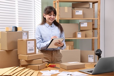 Parcel packing. Post office worker writing notes indoors