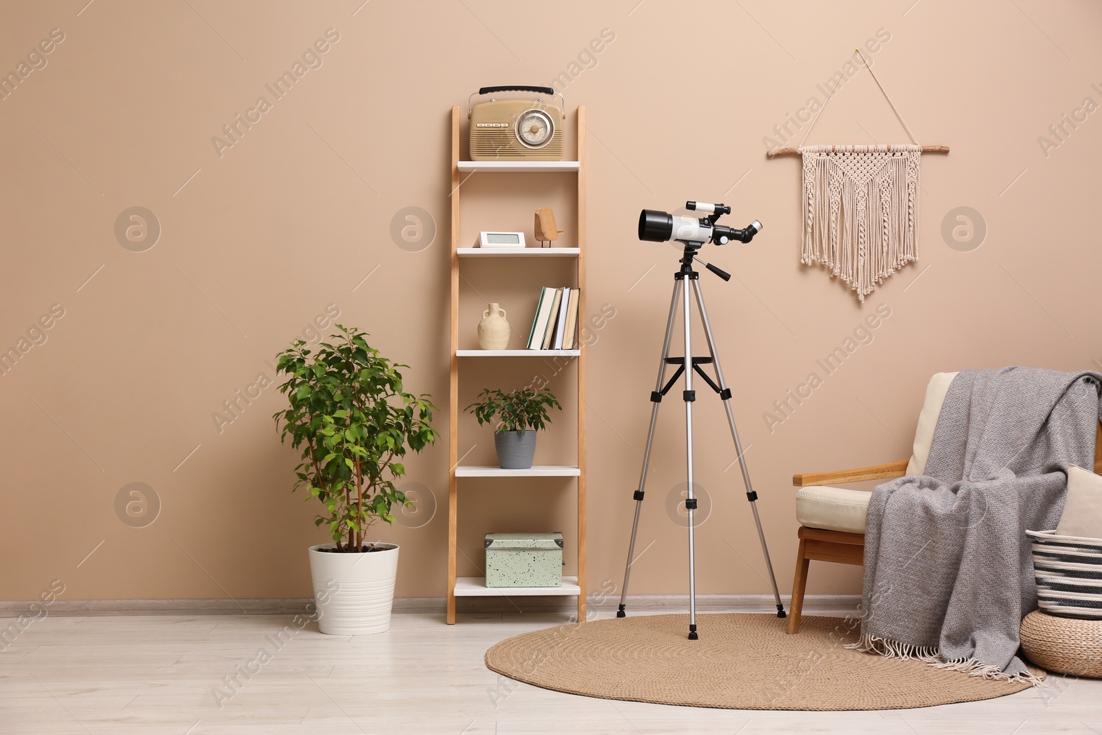 Photo of Tripod with modern telescope in stylish room