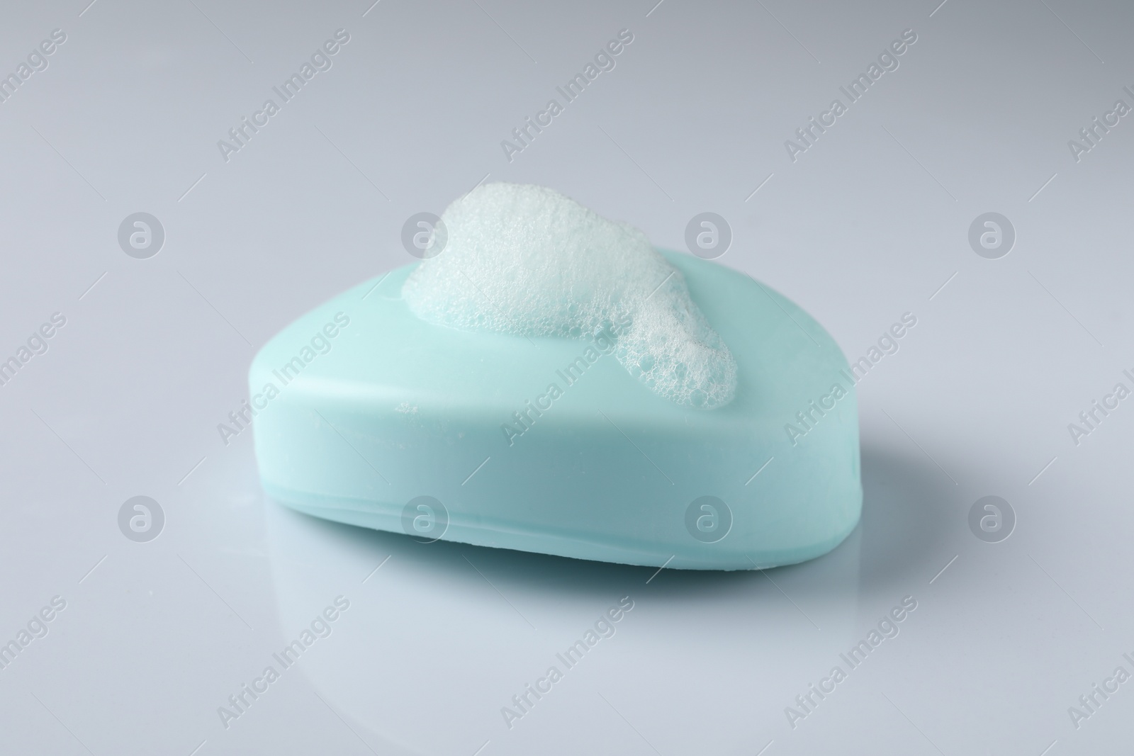 Photo of Soap with fluffy foam on white background