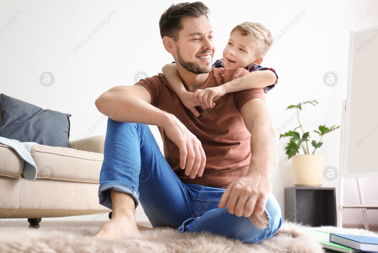Photo of Little boy and his dad spending time together at home
