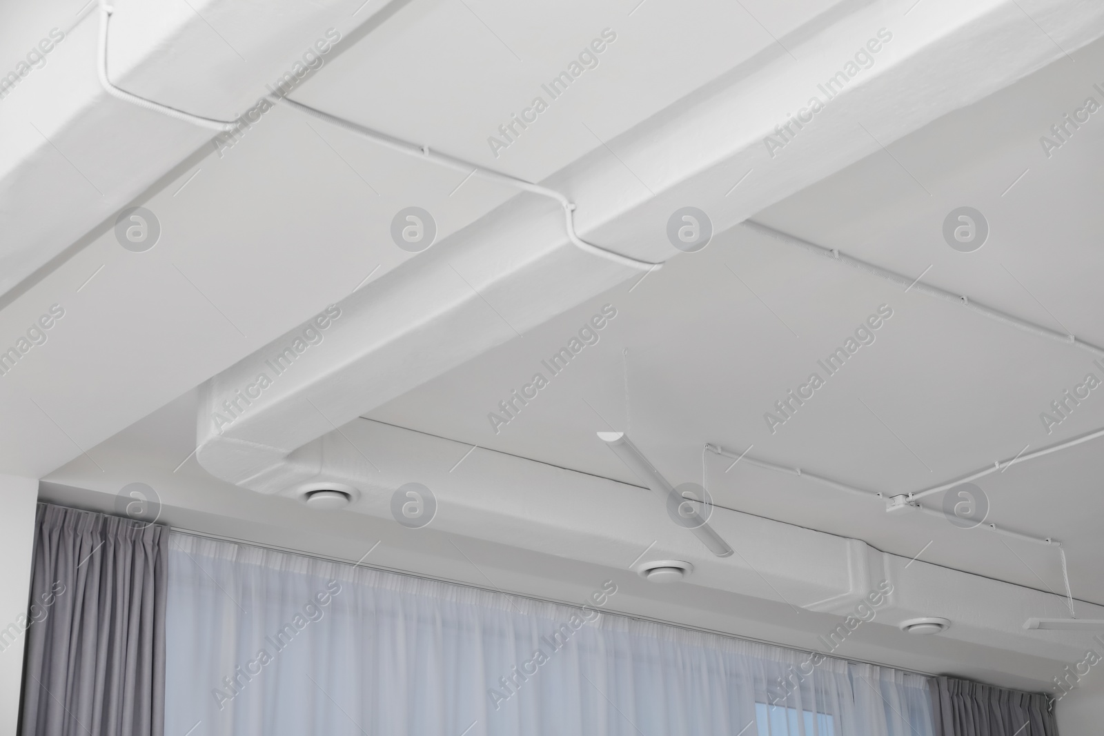 Photo of White ceiling with modern lighting in office