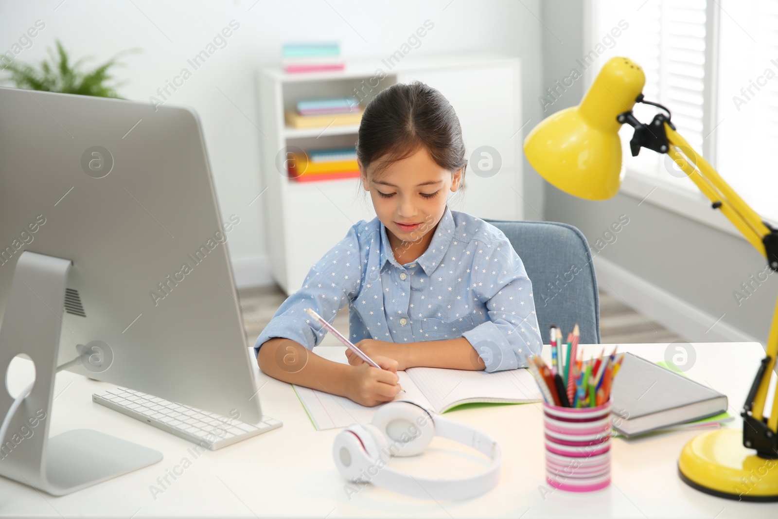 Photo of Distance learning, studying at home. Girl having online school lesson during quarantine and lockdown due to Covid-19 pandemic