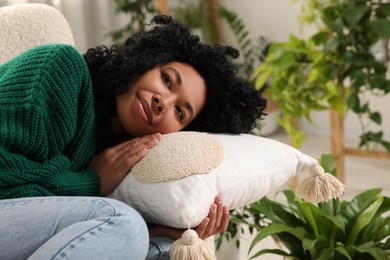 Woman relaxing near beautiful houseplants at home