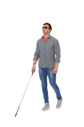 Photo of Young blind person with long cane walking on white background