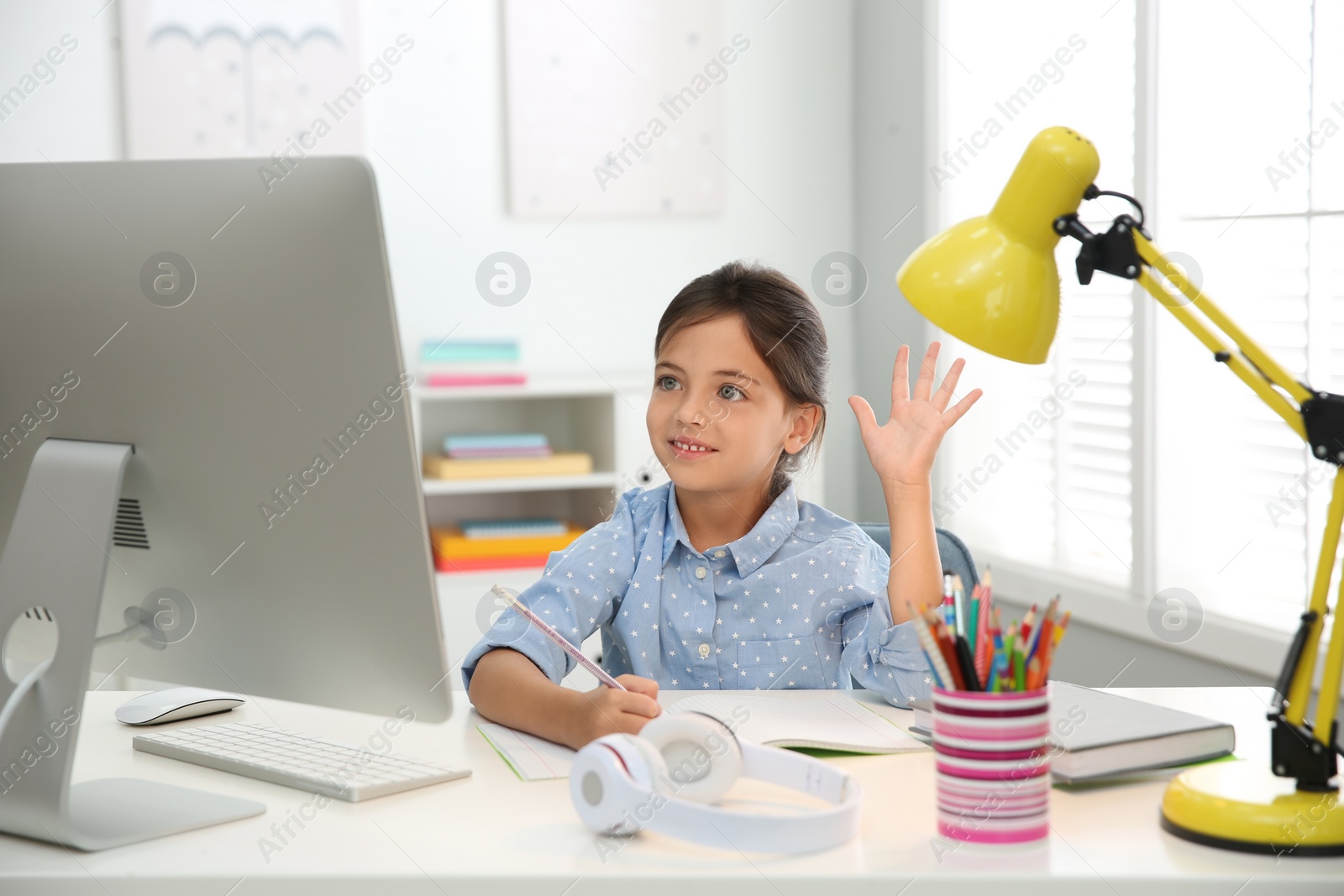 Photo of Distance learning, studying at home. Girl having online school lesson during quarantine and lockdown due to Covid-19 pandemic