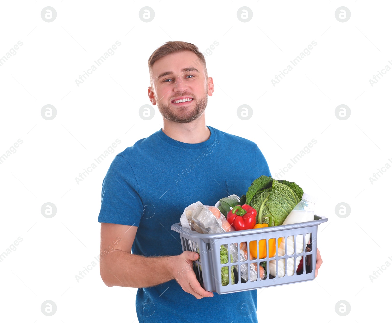 Photo of Delivery man holding plastic crate with food products on white background