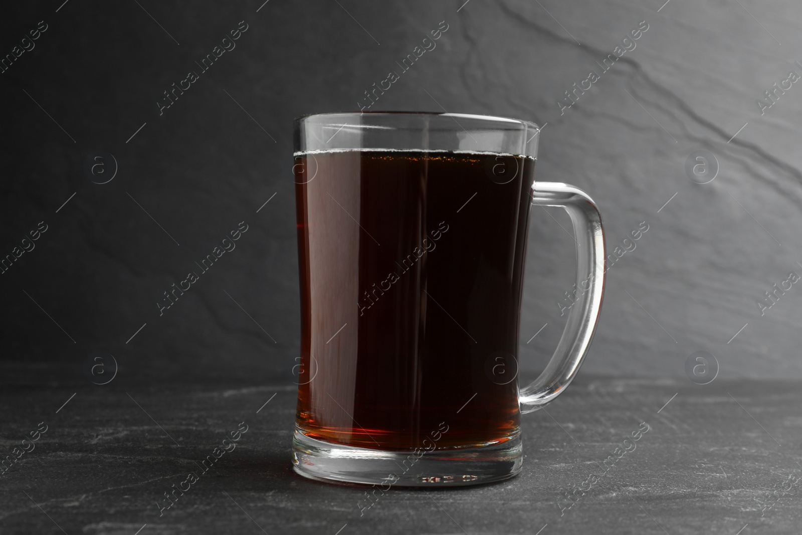 Photo of Mug of delicious kvass in mug on black table