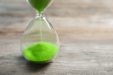 Hourglass with flowing sand on table. Time management