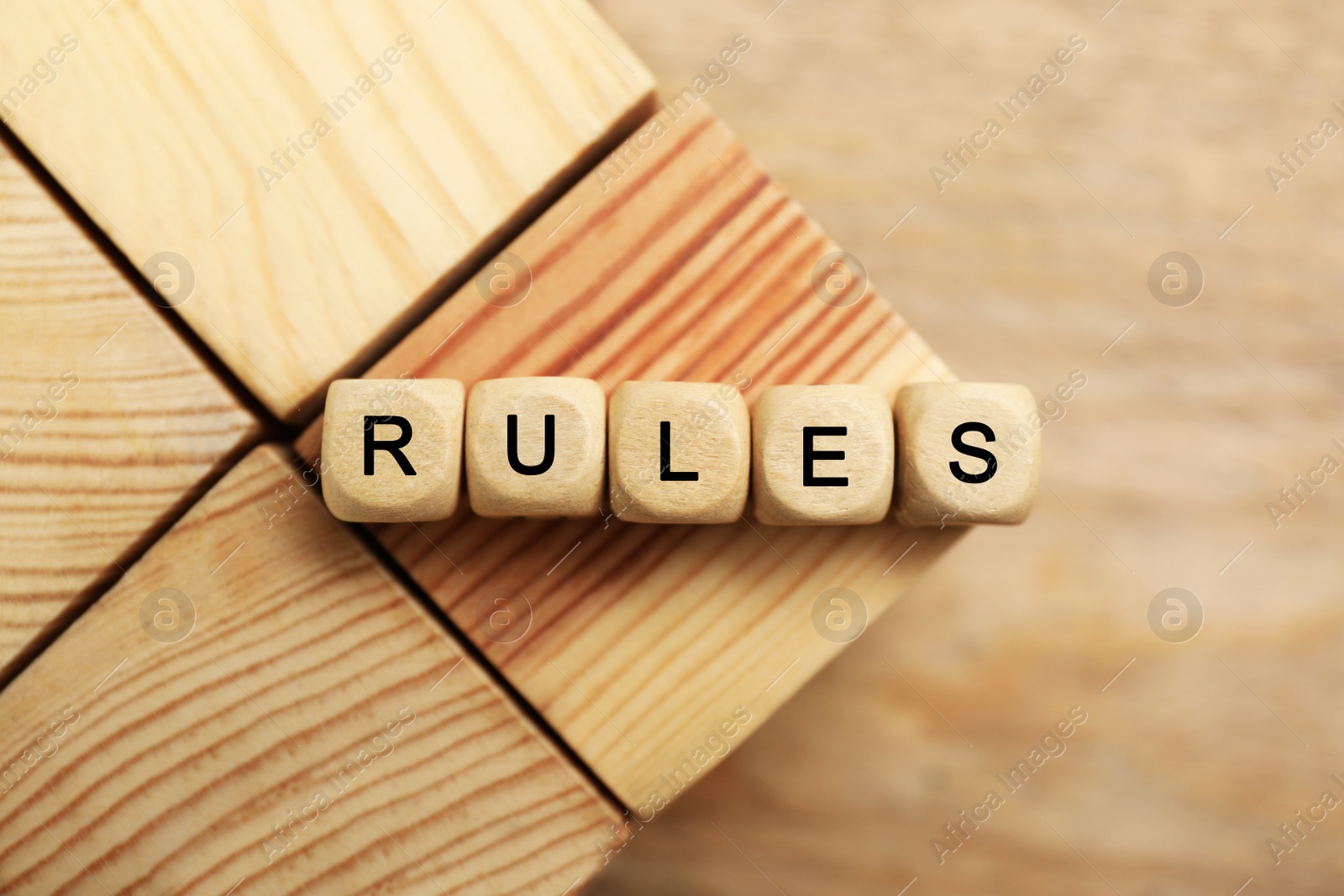 Photo of Word Rules made of cubes with letters on wooden blocks, top view