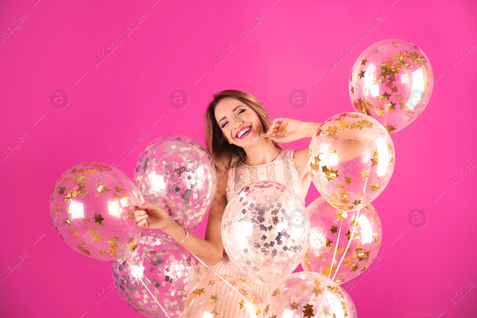 Photo of Young woman with air balloons on color background