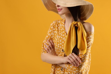 Photo of Woman with hat and stylish bandana on yellow background, closeup
