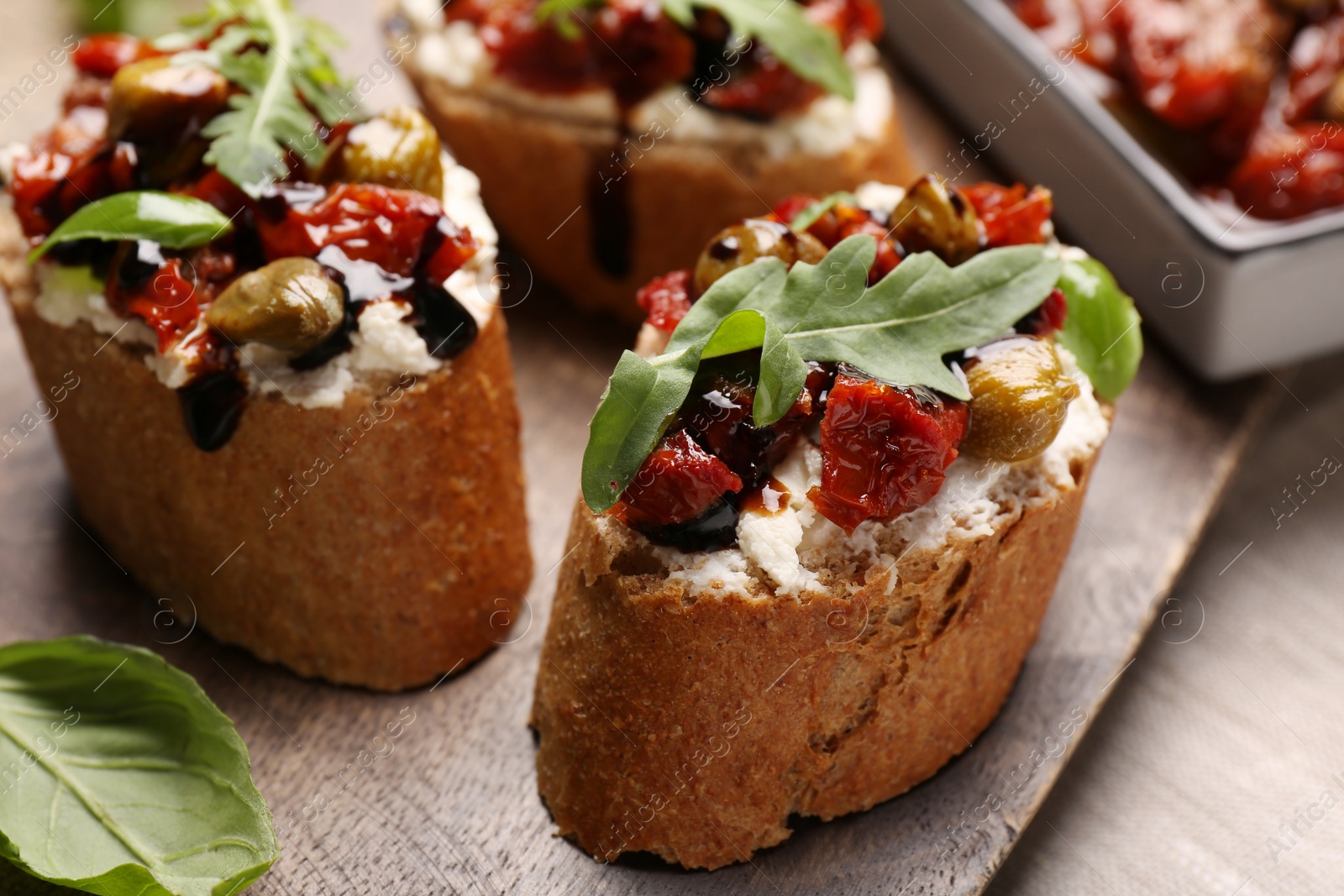 Photo of Delicious bruschettas with balsamic vinegar and toppings on table, closeup