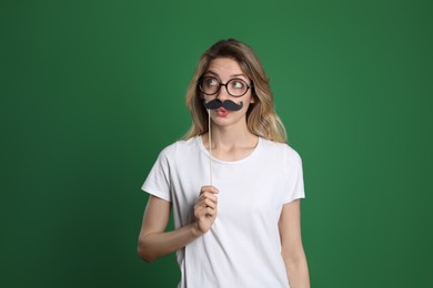 Photo of Funny woman with fake mustache on green background