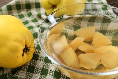 Delicious quince drink in glass bowl and fresh fruits on table, closeup